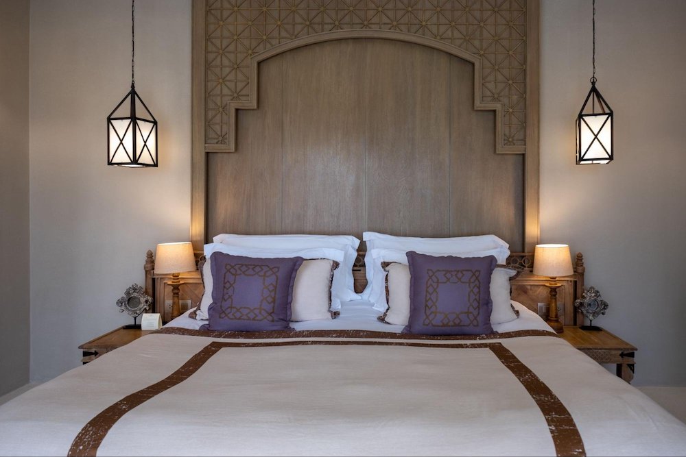 eleganckie łóżko ze stojącymi obok i wiszącymi lampkami nocnymi
